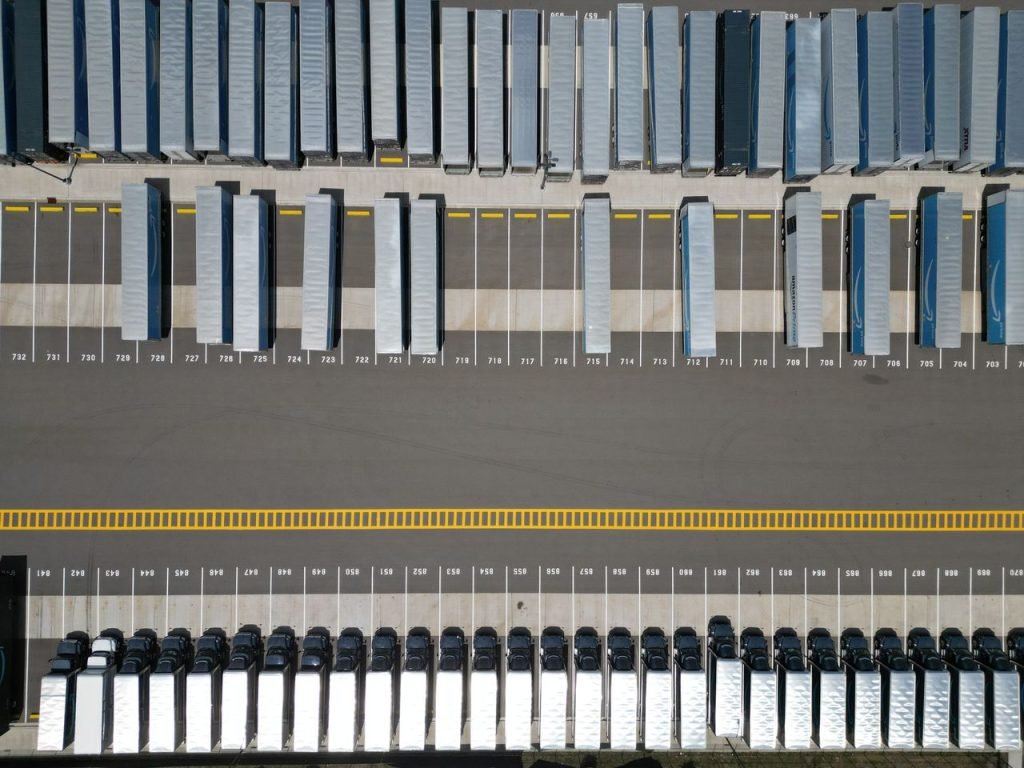 Crafting Captivating Headlines: Your awesome post title goes here High-angle shot of trucks parked in an organized grid in an industrial parking lot.